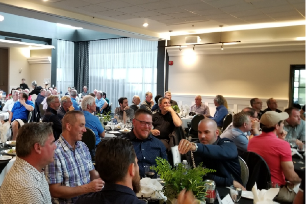 A photo of many people sitting at tables in a banquet hall.